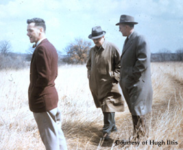 John Curtis walks through the prairie with three colleages